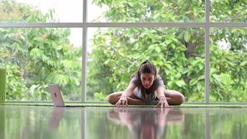 rilassata giovane donna che lavora a casa facendo yoga video