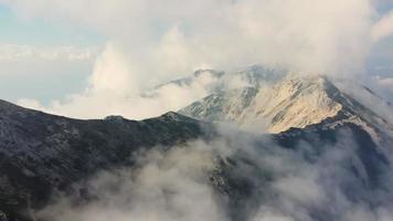 drone che vola sopra le cime delle montagne con la nebbia video