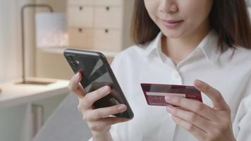Frau hält Smartphone und Kreditkarte video