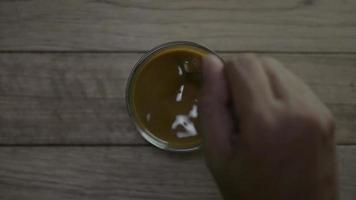 vista dall'alto della mano di persona mescolando caffè caldo in una tazza video