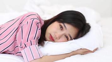 mujer joven asiática acostada en la cama video