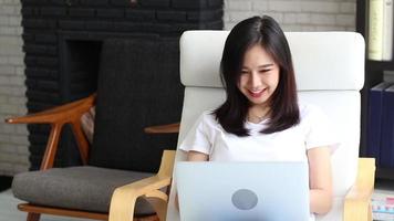 giovane donna asiatica che lavora con un computer portatile video