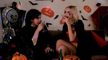 Couple drinks  together at Halloween party 