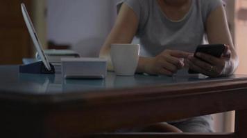 Mujer con teléfono inteligente móvil y tomando café video