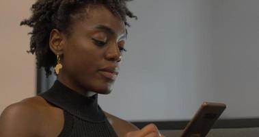 jeune femme afro-américaine millénaire sur téléphone video