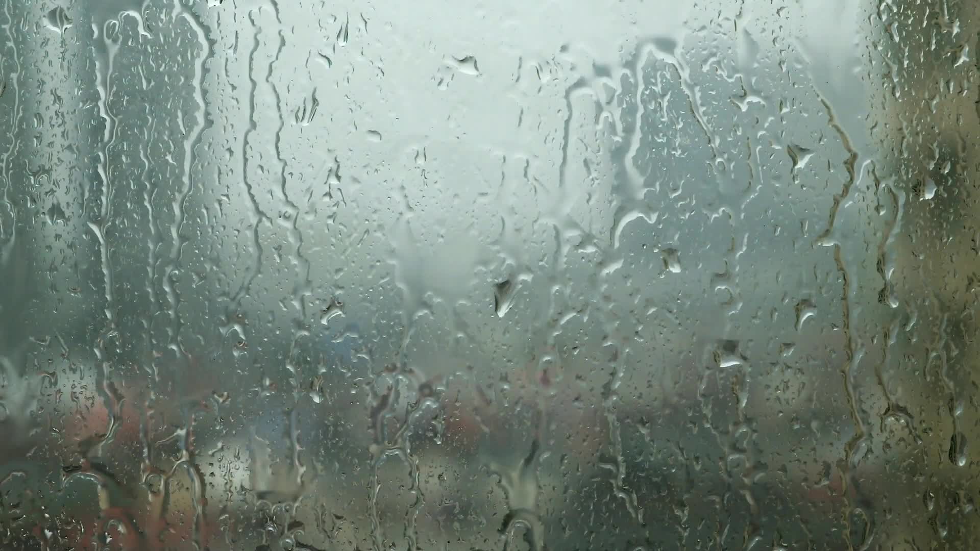 Raindrops trickling down on window glass during heavy rain 2020102