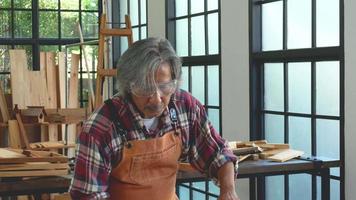 artesano asiático sopla un poco de polvo de un palo de madera video
