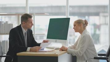 El empresario habla con una mujer joven durante una entrevista de trabajo