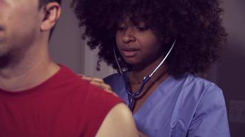 médica negra escuta a respiração do paciente video