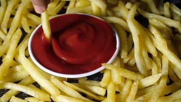 Hand dipping the french fries in tomato sauce video