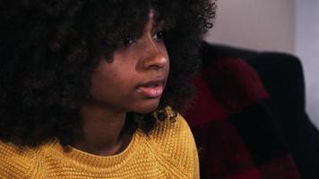 aufgeregte junge schwarze Frau, die fernsieht und feiert video