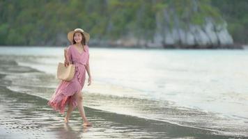 jeune femme asiatique marchant sur le rivage
