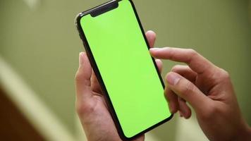 donna che utilizza smartphone con schermo verde