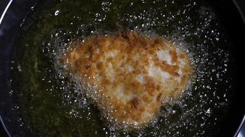 Cámara lenta de pollo frito en una sartén con aceite hirviendo video