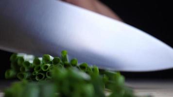 Chef uses a kitchen knife to slice a spring onions bunch video