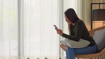 Woman using mobile phone on armchair video