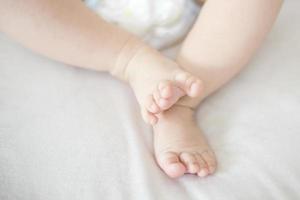 pequeños pies de niña en la cama foto