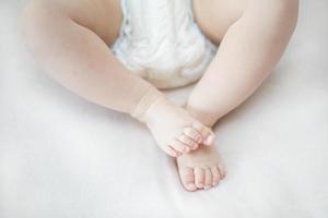 pequeños pies de niña en la cama foto