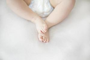 Small baby girl feet on the bed photo