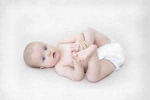 Cute baby girl lying on bed photo