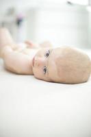 Cute baby girl lying on bed photo