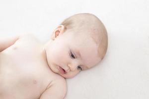 Cute baby girl lying on bed photo