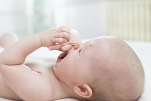 Cute baby girl crying on bed photo