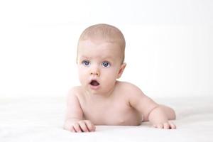 Cute baby girl lying on bed photo