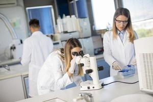 Group of young researchers analyzing chemical data in the laboratory photo