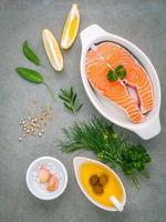 Filete de salmón en un recipiente blanco con ingredientes foto
