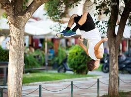 Young sportsman doing front flip in the street photo