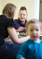 Grandmother and mother talking while child plays photo