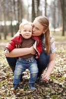 madre abrazando a hijo en un parque foto