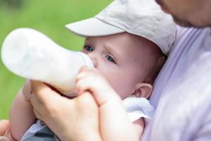 Man bottle feeding baby photo