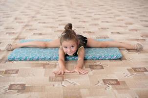 joven gimnasta haciendo un split en el suelo foto