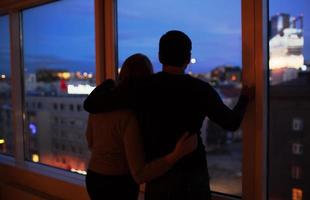 pareja abrazándose y mirando por la ventana foto