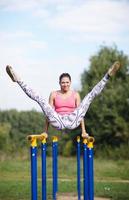 Athletic gymnast exercising on parallel bars
