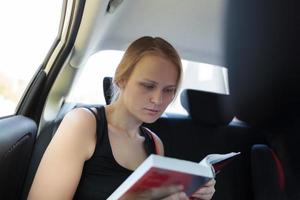 mujer leyendo un libro en un coche foto
