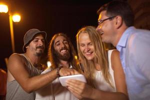 amigos divirtiéndose mirando un teléfono foto