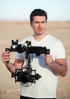 Videographer with steady-cam equipment on the beach photo