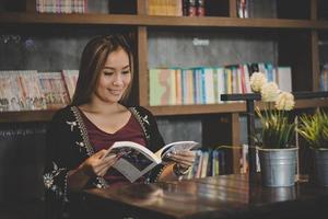 mujer de negocios feliz leyendo el libro mientras se relaja en el café. foto