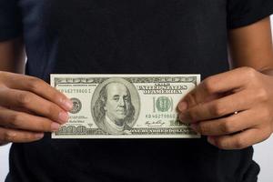 Close-up de la mano de una mujer sosteniendo dinero aislado sobre fondo blanco. foto