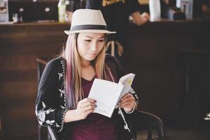 Mujer de negocios feliz leyendo el libro mientras se relaja en el café foto