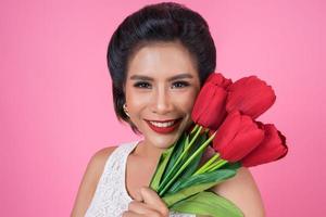 Portrait of a beautiful woman with bouquet of red tulip flowers photo