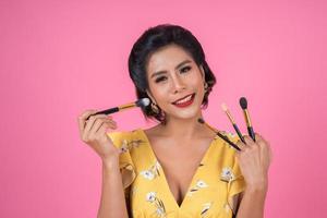 Portrait of a woman with makeup brushes photo