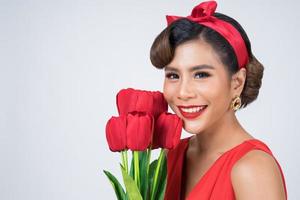 Portrait of a beautiful woman with bouquet of red tulip flowers