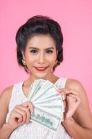 Happy beautiful woman holding dollars photo