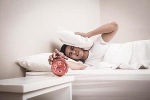 Man turns off the alarm clock in the morning