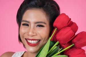 Portrait of a beautiful woman with bouquet of red tulip flowers photo