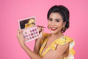 Portrait of a woman with makeup and cosmetic brush photo